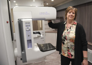 Deb Brower poses in front of a Spectrum Health mobile mammography unit.