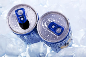 Two energy drinks sit in ice.