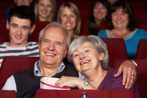 A group of people appear entertained at a movie.