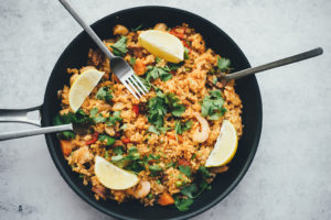 Shrimp fried rice with lemons and cilantro on top.