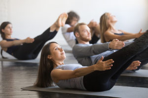A group of people appear to be exercising on yoga mats.