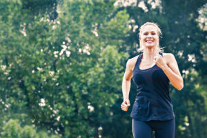 A person jogs outside and smiles.