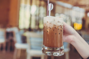 A person holds an iced mocha drink.