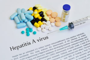 A pile of different sized pills and a vaccine are shown next to the words "Hepatitis A virus."