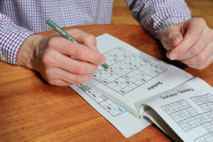 A man fills out a sudoku puzzle.