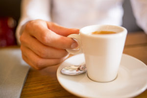 A person holds a cup of coffee.