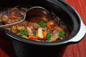 A slow cooker pot holds a hearty stew.