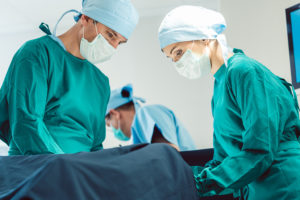 A group of surgeons conduct a C-section.