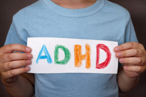 A person holds up a sign that says, "ADHD."