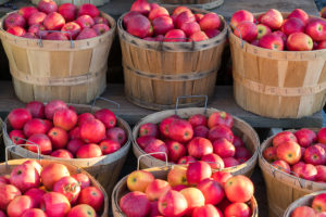 Bushels of red apples are shown.