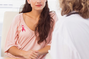 A young woman talks to her doctor about breast cancer.