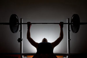 A person participates in weight training by lifting weights.