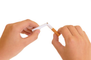 A person breaks a cigarette in half to symbolize quitting.