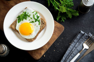 A whole grain piece of toast is shown with a fried egg on top.