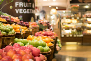The produce aisle of a grocery store is in focus.