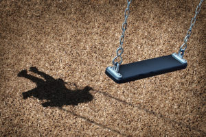 An empty swing set is shown to symbolize an empty playground during a pandemic.
