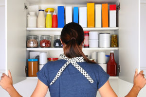 A person looks in their cupboard for a meal to cook.
