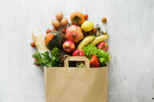 A grocery bag is filled with fresh produce.