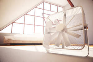 A white box fan is shown inside a room.