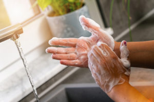 A person washes their hands to reduce transmission of COVID-19.