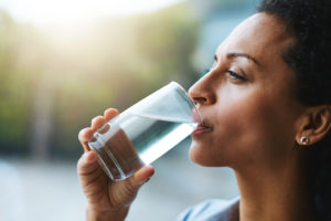 A person drinks a glass of water.