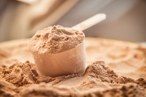 A scoop full of protein powder is shown.